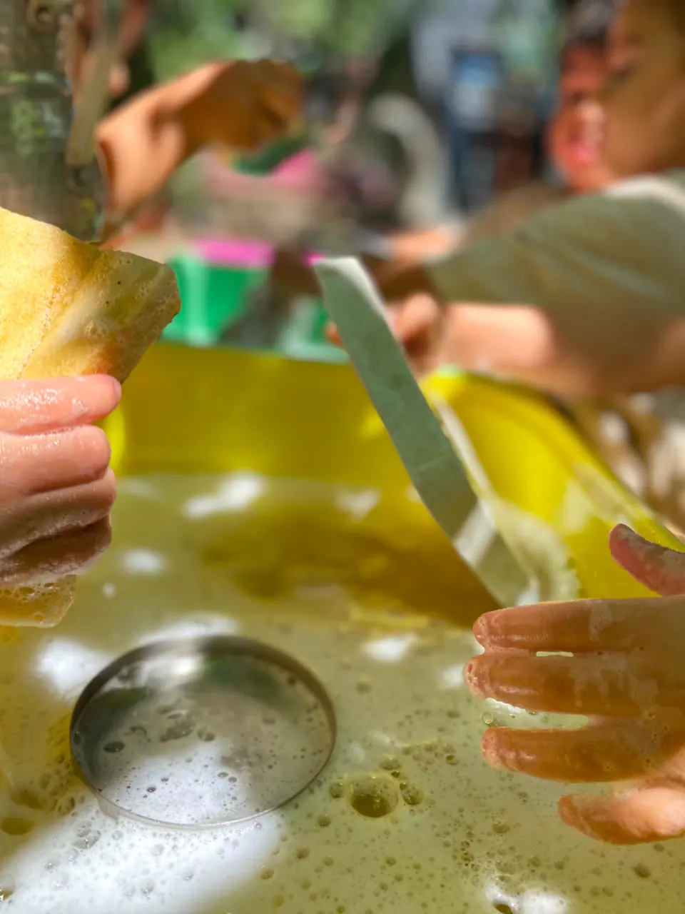 Çocukların sünger ve köpüklü suyla yaptığı yıkama oyunu